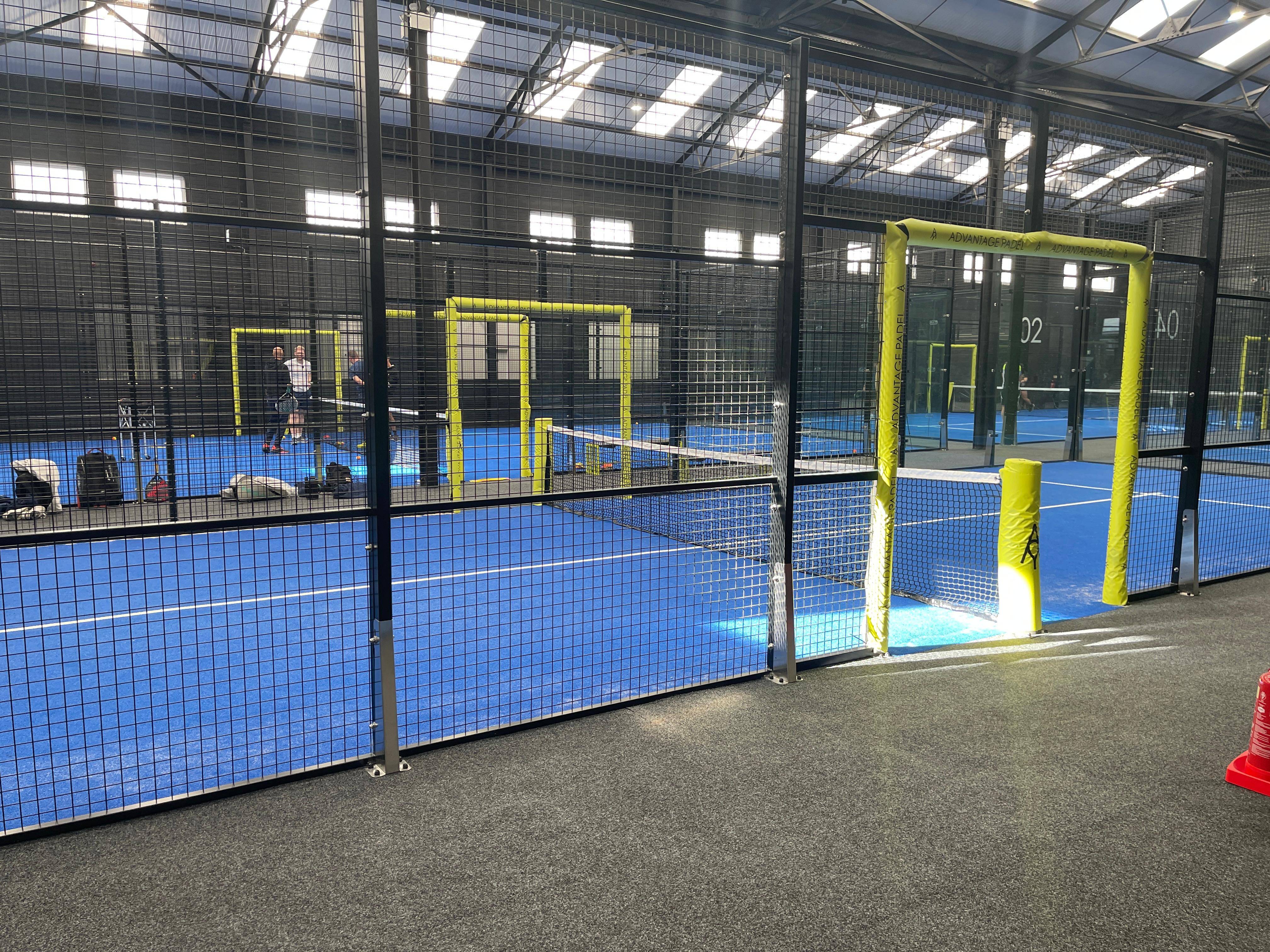 Rows of blue panoramic padel courts with players during a daytime session